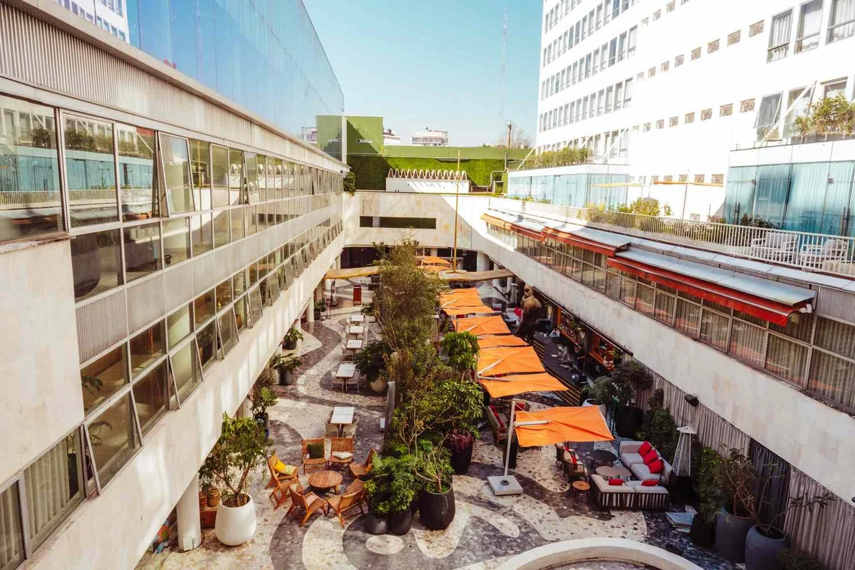 The hotel courtyard with orange umbrellas, plants and patterned stone floors