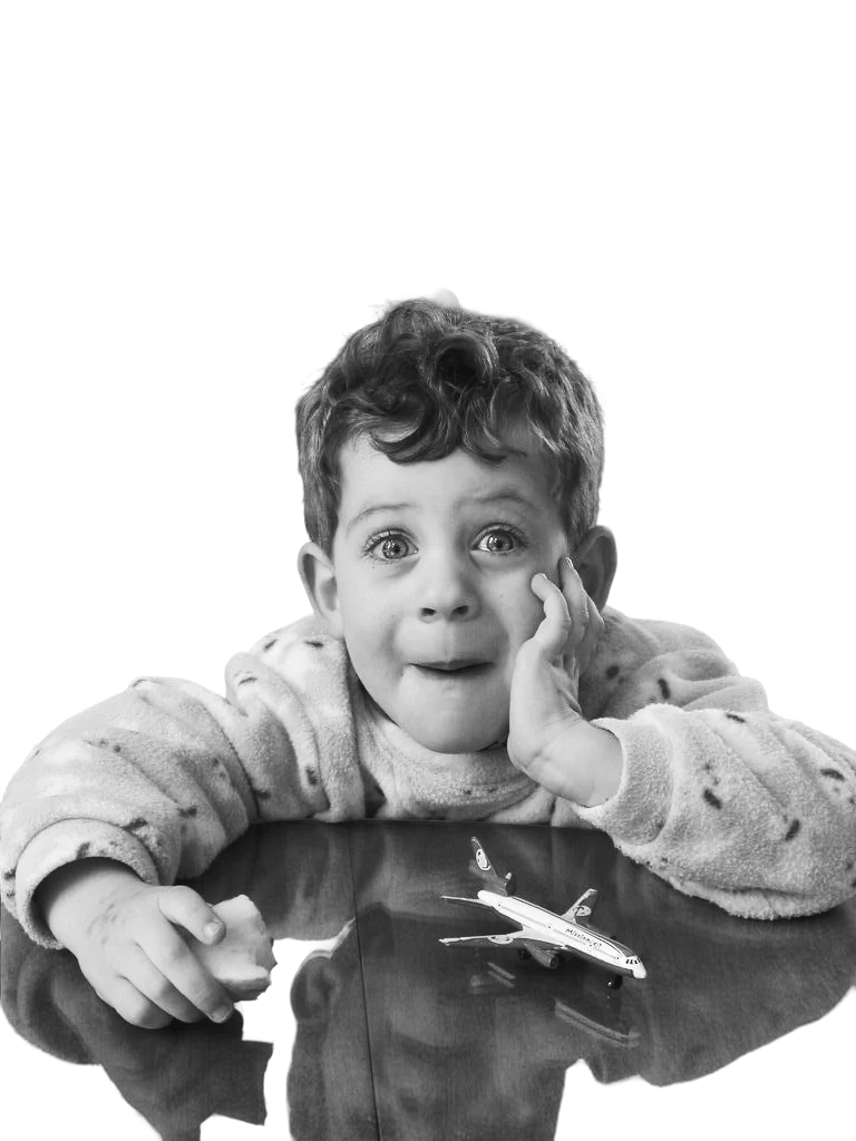 Cooper as a little kid, chin in hand, with a toy plane