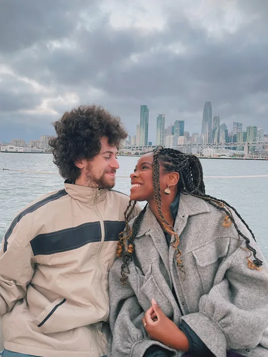 Cooper and Ciera by the water with a city skyline behind them