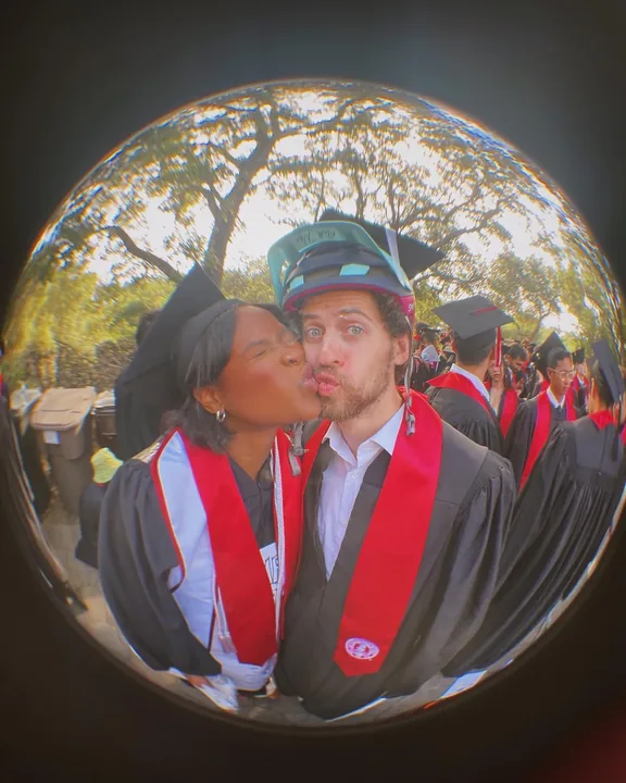Ciera and Cooper kissing at graduation, seen through a fisheye lens