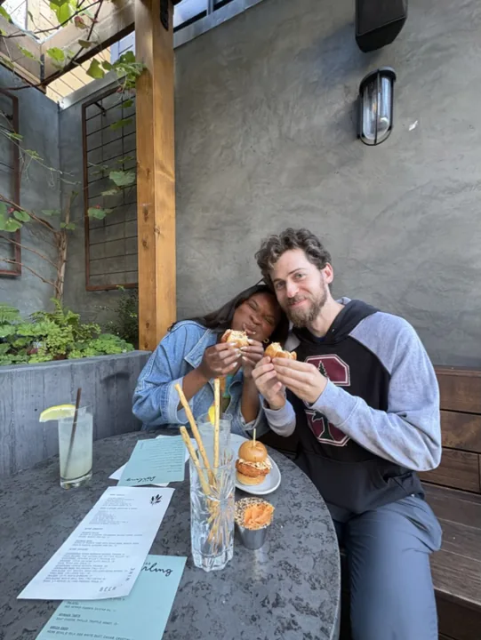 Ciera and Cooper toasting at an outdoor café table