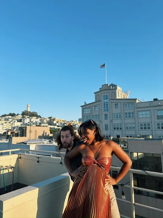 Ciera and Cooper on a sunny rooftop overlooking the city